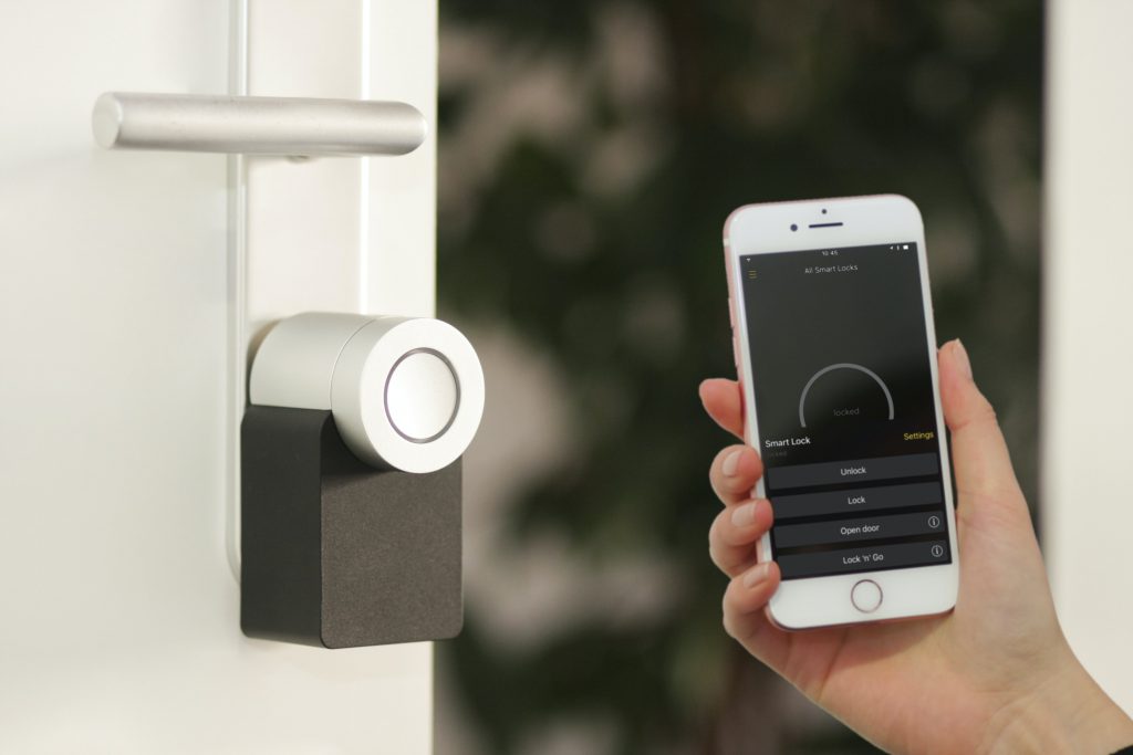 Image of hand holding a phone pointing to a digital lock