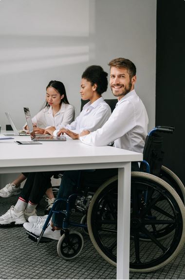 Image of man in a wheelchair at a desk