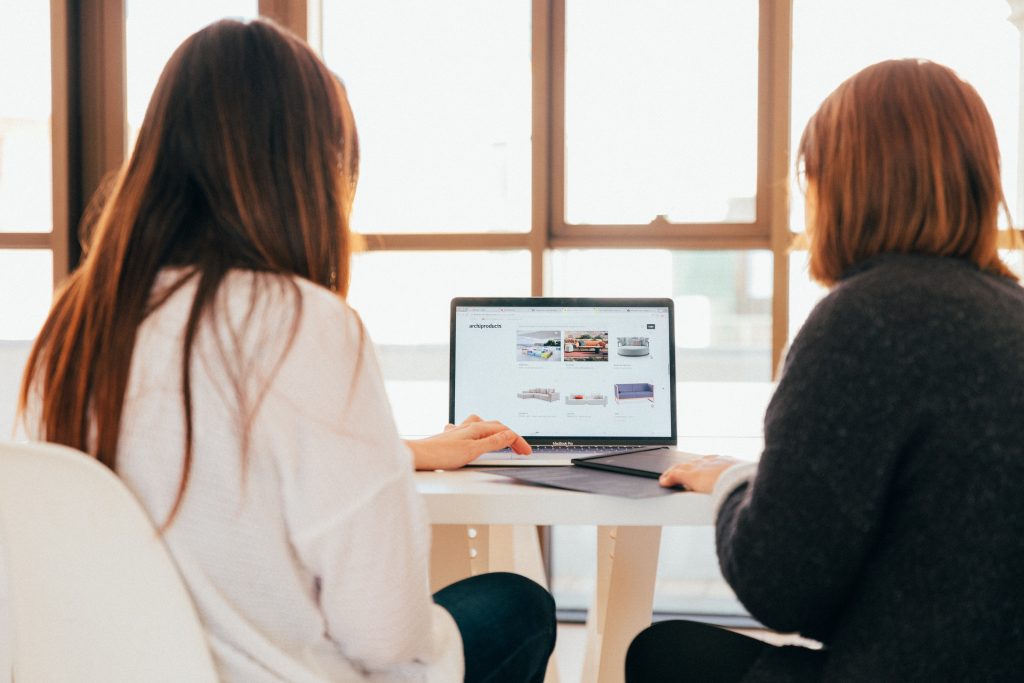 Image of two women looking at a laptop screen