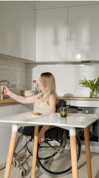image of woman on a wheelchair in the kitchen makeing tea